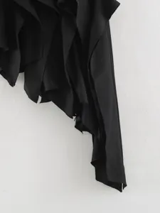 Detail view of black irregular ruffle skirt drape ribbon hemline fashion apparel close up