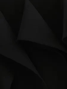 Black irregular ruffle skirt fabric detail, soft drape texture close-up, fine stitching.
