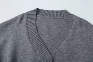 Grey knit sweater V-neck detail view showing fine ribbing texture and elegant style.