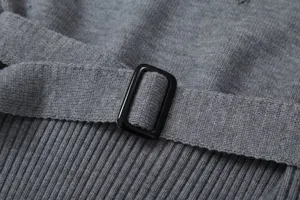 Close-up detail of women's gray knitted garment featuring a chic waist belt and black buckle.