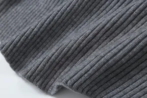 Grey ribbed knit fabric texture close-up, soft and stretchy detail view for autumn apparel.
