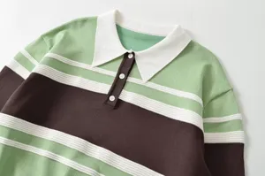 Close-up detail of color-block striped knitted polo shirt showing collar and button placket.