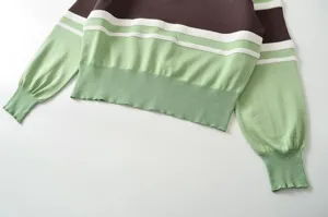 Close-up view of the color-block striped knit sweater showing textured ribbed cuffs and hem.