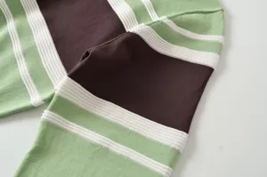 Close-up knit detail of women's color-block striped pullover with ribbed texture fabric.