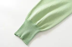 Light green knit sweater sleeve detail, featuring a ribbed cuff for a cozy, stylish look.