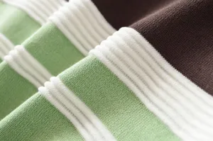 Close-up detail of women's colorblock striped knit sweater fabric, soft and cozy texture.