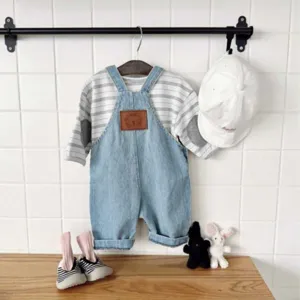 Detailed view of kids striped long sleeve t-shirt and denim overalls set with cute accessories.