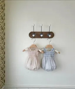 Detail view of baby summer smocked strap rompers in pink stripe and blue gingham designs.