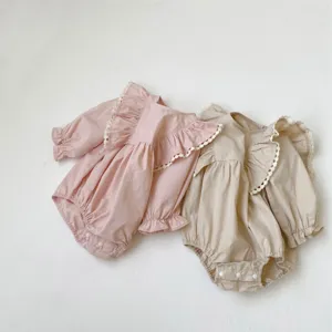 Adorable infant baby girl long sleeve ruffle romper with delicate lace trim details.