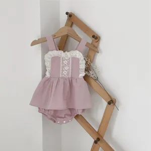 Detailed view of baby girl cotton pink rompers with delicate lace ruffles and cute suspender design.