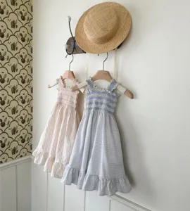Detailed view of cute baby girl summer sleeveless smocked dresses in pink stripe and blue gingham.