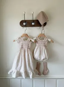 Detailed shot of baby girl summer dress, smocked romper, bonnet and socks set, beige stripe cute outfit.