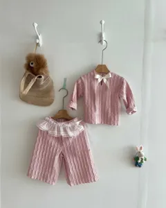 Detailed view of baby girl pink jacquard long-sleeve top and lace ruffle pants set.