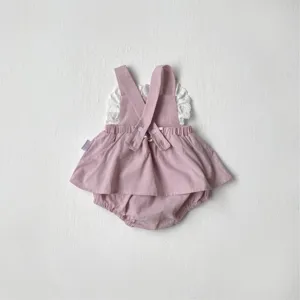 Detailed view of the cute pink baby romper featuring delicate white lace trim and straps.