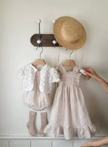 Detailed view of baby girl summer dress and lace cardigan set, soft breathable fabric texture