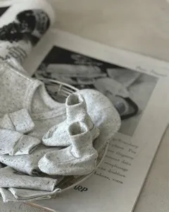 Detail van de babykleding set van gevlekt katoen met schattige gebreide babyslofjes.