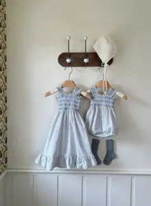 Detailed view of summer baby girl blue white plaid smocked dress and matching bonnet socks set.