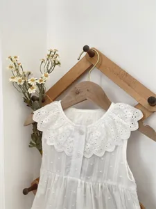 Close-up view of white baby romper with sweet lace collar, soft cotton infant clothing.