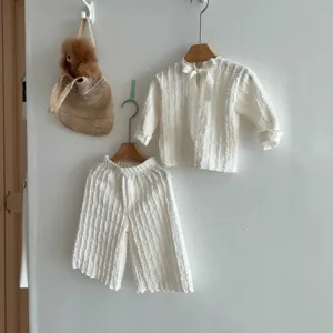 Detail view of baby girl autumn bow jacquard long-sleeve top and wide-leg pants set.