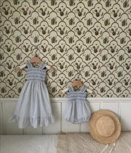 Charming baby girl summer blue gingham smocked strap dress and romper set for toddlers.