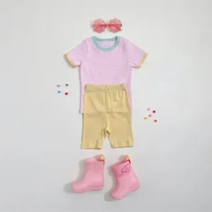 Sommer-Outfit Set für Kinder mit gepunktetem Kurzarmshirt, kurzen Hosen und passenden Stiefeln.