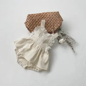 Close-up detail of cute baby cotton romper with delicate lace trim and sweet straps design.
