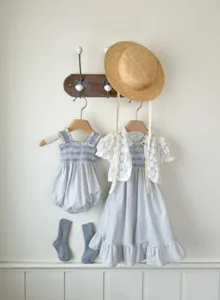 Baby girl summer dress set featuring a blue plaid smocked strap dress and white lace cardigan.