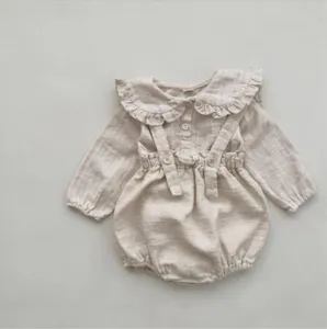 Adorable barboteuse bébé à volants et bretelles dans un style lin minimaliste détail.