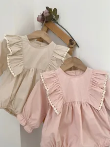 Detail view of baby girl long sleeve romper featuring elegant big ruffles and delicate lace trim.