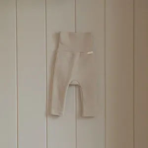 Vista dettagliata dei pantaloni neonato vita alta in cotone beige, vestibilità comoda.