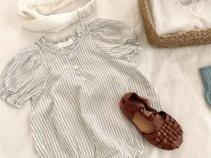 Detailaufnahme des gestreiften Baby-Bodys mit süßen Puffärmeln und hübschem Rüschenkragen.