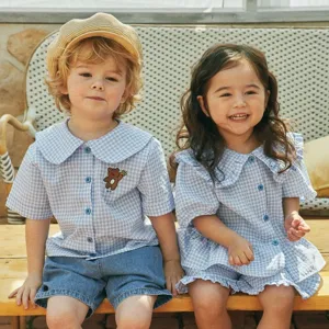 Outdoor scene detail showing baby toddler gingham shirt and shorts set with cute bear detail.