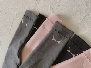 Dettaglio in primo piano dei leggings autunnali da bambina ricamati, morbido tessuto.