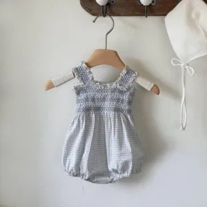 Detailed view of the baby girl summer blue checkered smocked romper with cute ruffled straps.