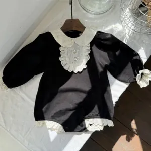 Chic baby girl black romper with white lace collar and pearl buttons for infant photography.