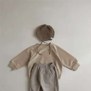 Infant casual outfit detail, knit bonnet and embroidered sweatshirt with striped trousers set.