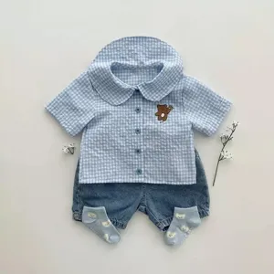 Cute baby summer outfit set featuring blue checkered shirt, denim shorts, and matching socks.