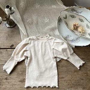 Baby Strick-Oberteil mit Stehkragen und Puffärmeln im Detail mit feinen Rüschen und weichem Stoff.