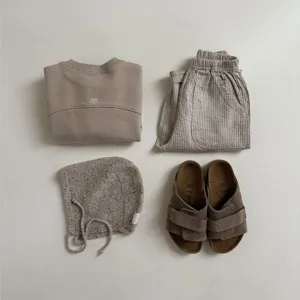Detailed view of baby spring cotton casual pants set with matching sweatshirt and knit accessories.