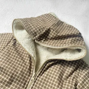 Detailed view of baby winter brown plaid fleece lined hooded jacket zipper close-up texture.