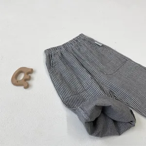 Close-up of kids cotton casual pants with vintage stripes, large pockets and houndstooth cuffs.