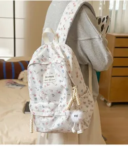 Floral print canvas backpack for daily school and casual wear with cute plush pendant.