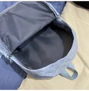 Detailed view of light blue woven grid student backpack interior showing ample space.