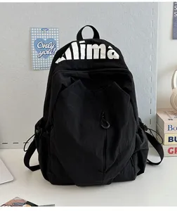 Detail shot of black lightweight water-repellent backpack featuring alima print and front pocket.