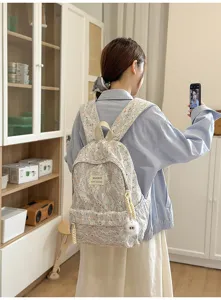 Floral lace backpack detail showing front pocket and cute charm accessory for daily use.