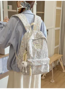 Detailed view of the fresh lace floral backpack with cute fluffy pendant, casual daily style.