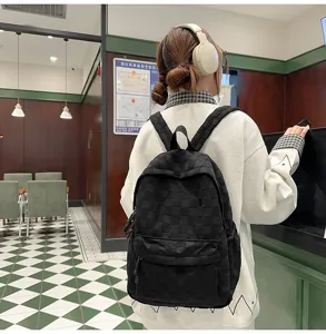Detailed view of casual black checkered backpack for women, stylish and spacious school bag.
