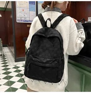 Black checkered casual backpack close-up detail showing stylish pattern and everyday wear.