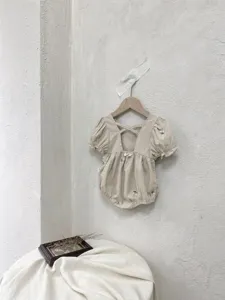 Exquisite detail of baby girl summer woven cotton romper with delicate floral embroidery.