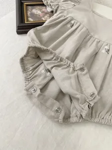 Baby girl woven cotton romper detail, delicate floral embroidery, bubble sleeves, snap crotch.